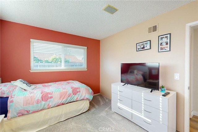 carpeted bedroom featuring a textured ceiling