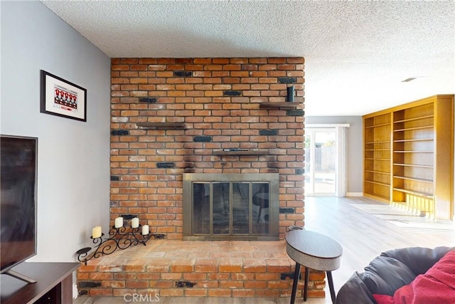 living room with a fireplace, a textured ceiling, and hardwood / wood-style flooring