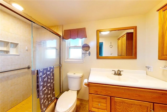 bathroom with a shower with door, vanity, and toilet