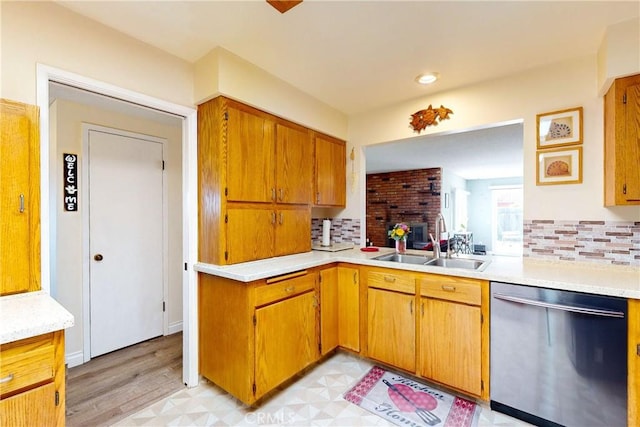 kitchen featuring light wood-type flooring, tasteful backsplash, stainless steel dishwasher, and sink