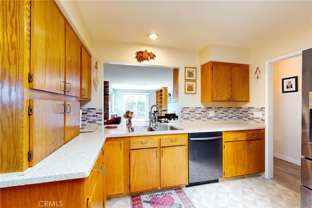 kitchen featuring decorative backsplash, dishwasher, light hardwood / wood-style floors, and sink