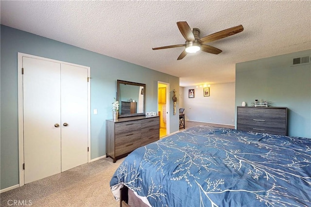 carpeted bedroom featuring a textured ceiling, a closet, and ceiling fan