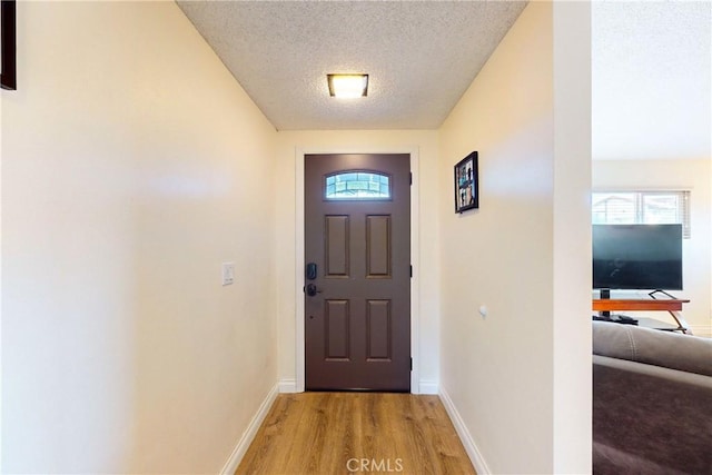 entryway featuring light hardwood / wood-style floors and a textured ceiling