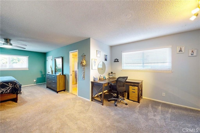 office area featuring light carpet, ceiling fan, and a textured ceiling