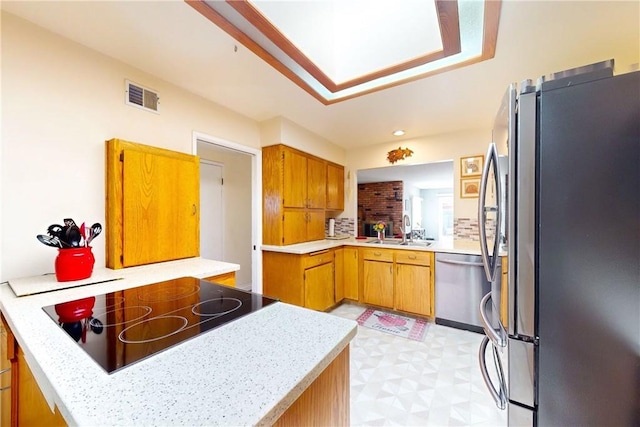 kitchen featuring kitchen peninsula, stainless steel appliances, and sink