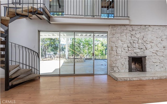 unfurnished living room featuring a healthy amount of sunlight, wood-type flooring, and a fireplace