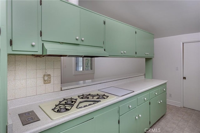 kitchen with green cabinetry, white gas cooktop, and tasteful backsplash