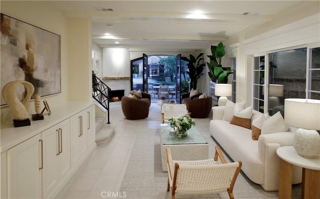 living room featuring beamed ceiling and light tile patterned floors