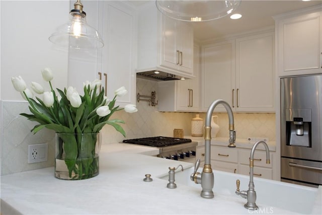 kitchen with white cabinets, stainless steel fridge with ice dispenser, backsplash, and pendant lighting