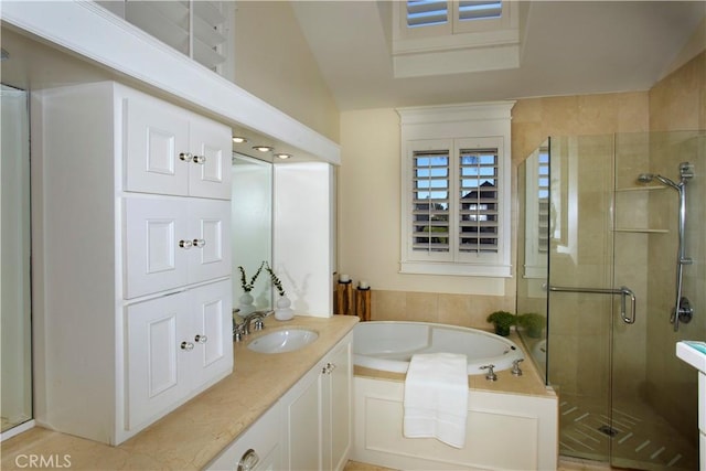 bathroom featuring vanity, separate shower and tub, and vaulted ceiling