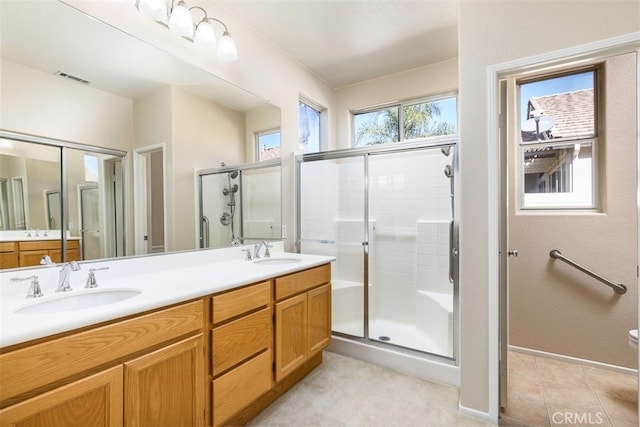 bathroom with a sink, visible vents, and a shower stall