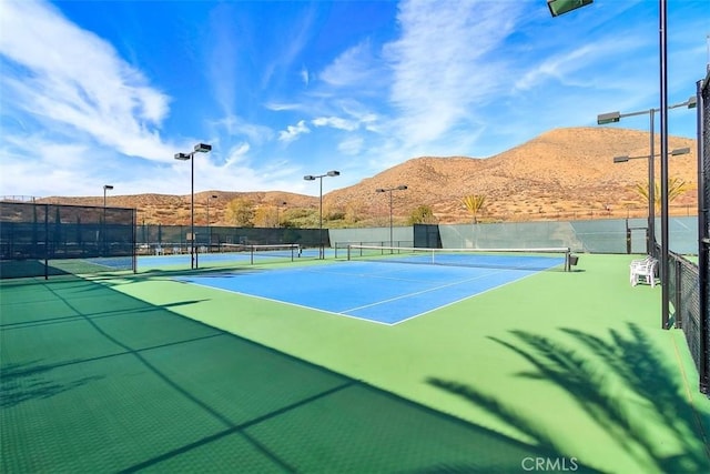 view of sport court featuring fence and a mountain view