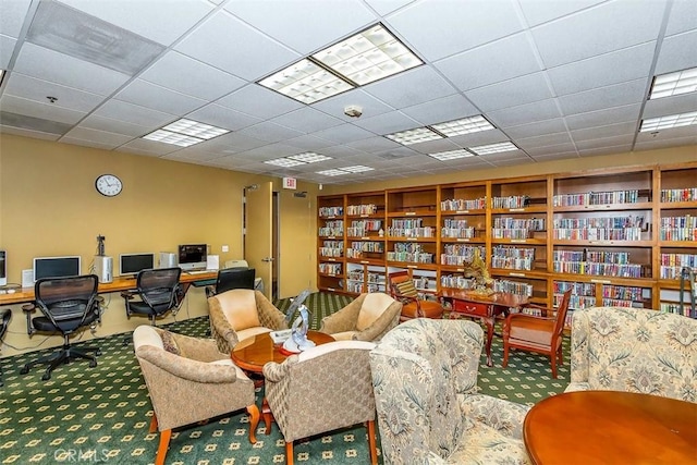 sitting room featuring carpet floors and a drop ceiling