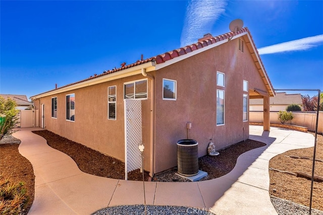 view of home's exterior with a tile roof, a patio area, a fenced backyard, and stucco siding