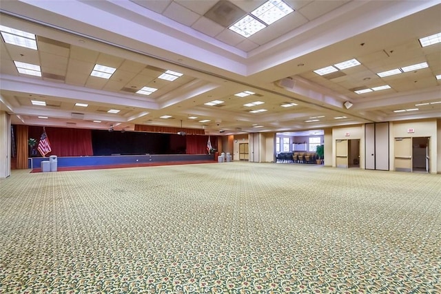 interior space with a paneled ceiling and carpet flooring