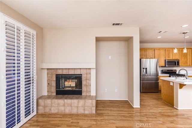 kitchen with light countertops, hanging light fixtures, visible vents, appliances with stainless steel finishes, and open floor plan