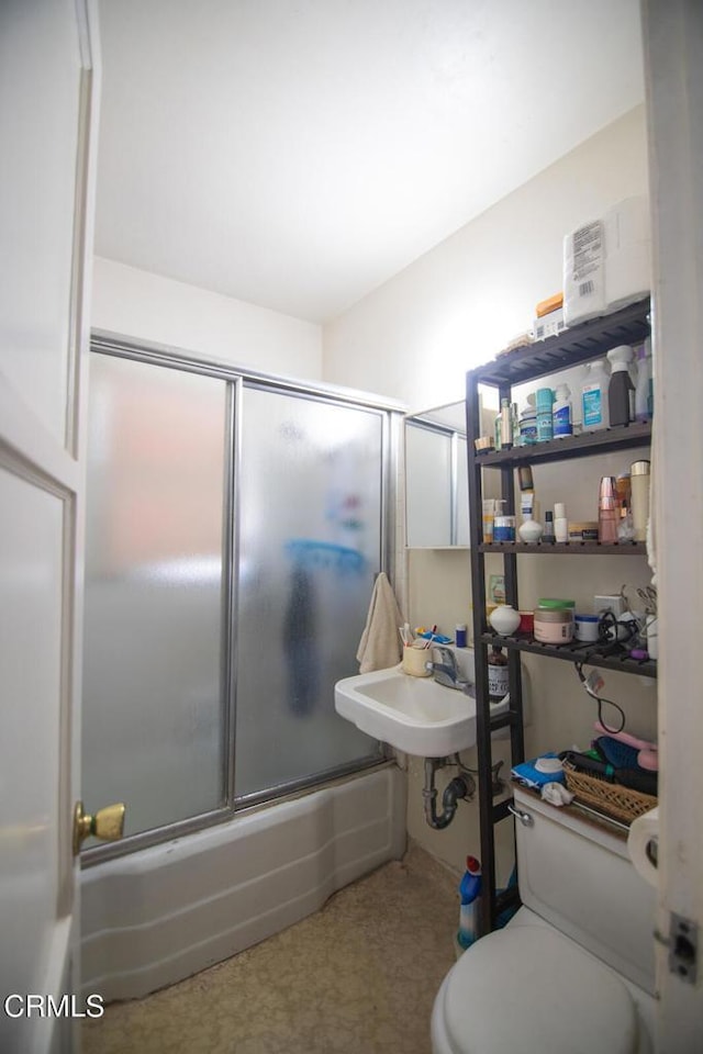 full bathroom with bath / shower combo with glass door, toilet, and sink