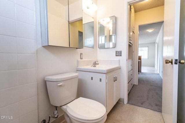 bathroom with vanity, a textured ceiling, and toilet