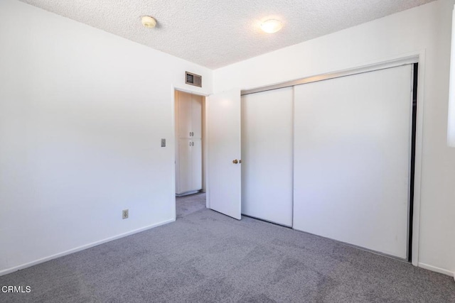 unfurnished bedroom featuring a closet, carpet, and a textured ceiling