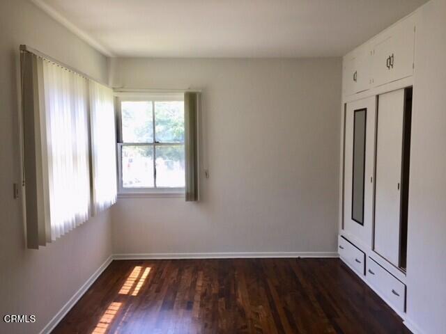 unfurnished bedroom with dark hardwood / wood-style flooring