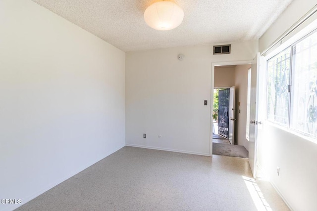 unfurnished room featuring a textured ceiling