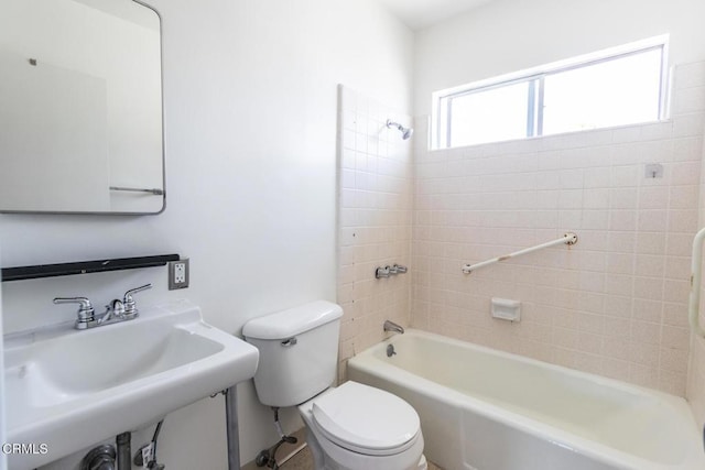 full bathroom featuring sink, tiled shower / bath combo, and toilet