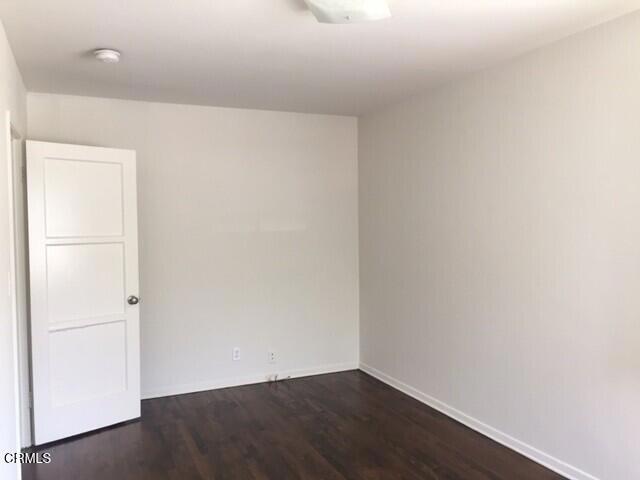 unfurnished room featuring dark hardwood / wood-style flooring