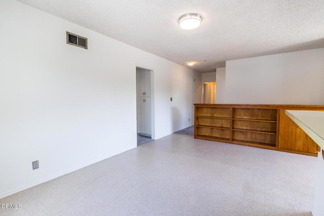 unfurnished room featuring a textured ceiling