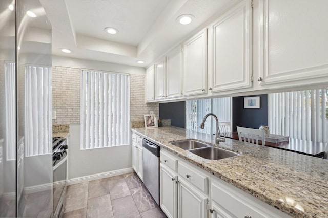 kitchen featuring white cabinetry, sink, stainless steel appliances, tasteful backsplash, and light stone counters