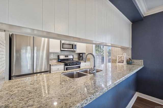 kitchen featuring sink, stainless steel appliances, crown molding, decorative backsplash, and white cabinets