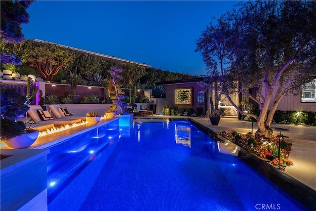 view of pool with a patio and a fire pit