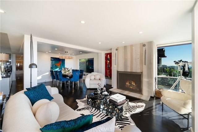 living room featuring expansive windows, a fireplace, and dark wood-type flooring