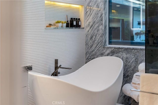 bathroom featuring a bathing tub and tile walls