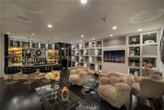 interior space with hardwood / wood-style floors, built in shelves, and indoor bar