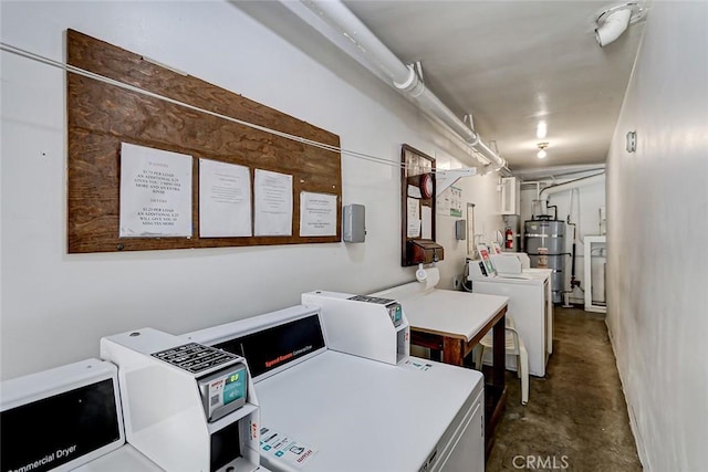 clothes washing area featuring secured water heater and washing machine and clothes dryer