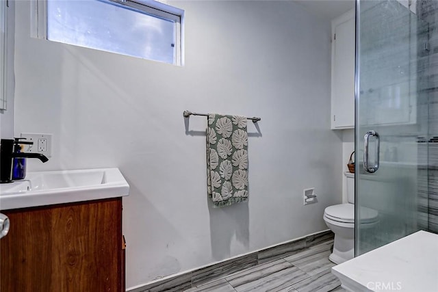 bathroom with vanity, toilet, and an enclosed shower