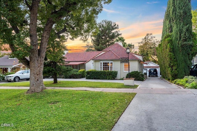 view of front of property with a yard, an outbuilding, and a garage