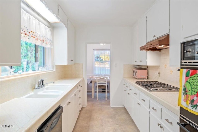 kitchen featuring white cabinets, stainless steel appliances, tasteful backsplash, and sink