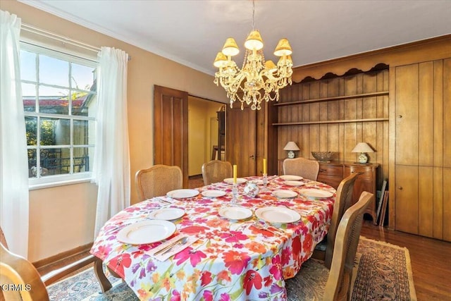 dining area with crown molding, hardwood / wood-style floors, and a notable chandelier