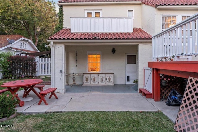 rear view of property with a balcony and a patio area