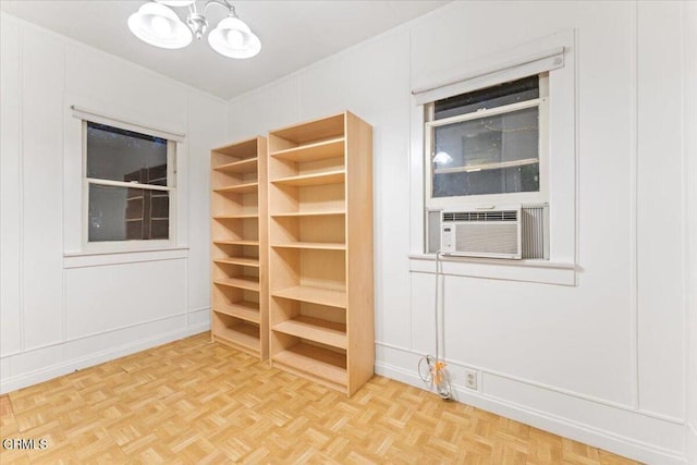 unfurnished room with parquet flooring, cooling unit, and a notable chandelier