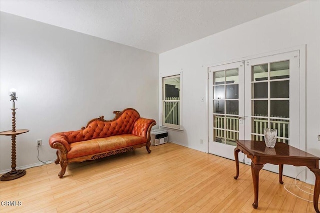 sitting room featuring french doors and light wood-type flooring