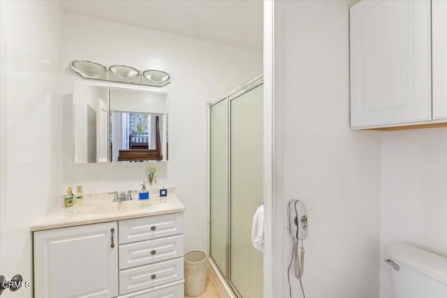 bathroom featuring vanity, toilet, and walk in shower