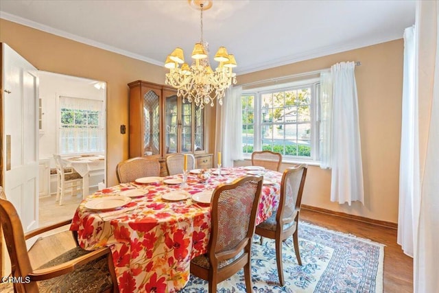 dining room featuring light hardwood / wood-style flooring, an inviting chandelier, and ornamental molding