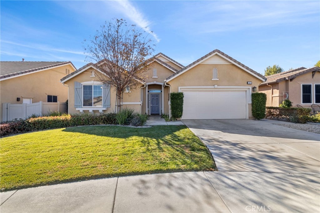 ranch-style home with a garage and a front lawn