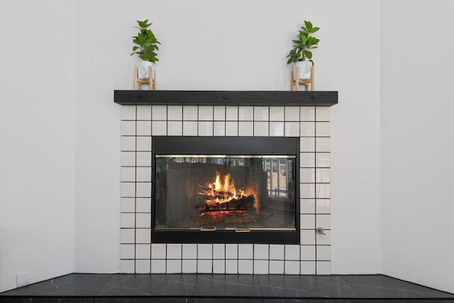 interior details featuring a tile fireplace