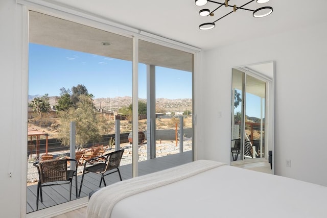 bedroom featuring multiple windows, hardwood / wood-style flooring, floor to ceiling windows, and a notable chandelier