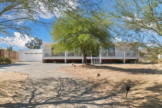 view of front facade featuring a wooden deck and a garage