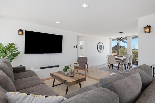 living room with light hardwood / wood-style floors and a chandelier