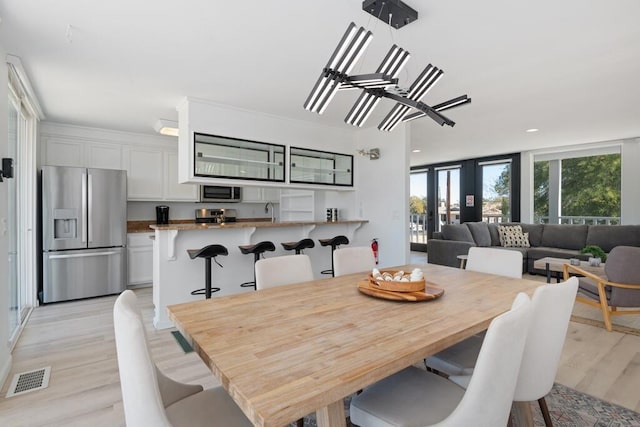 dining space featuring french doors and light wood-type flooring